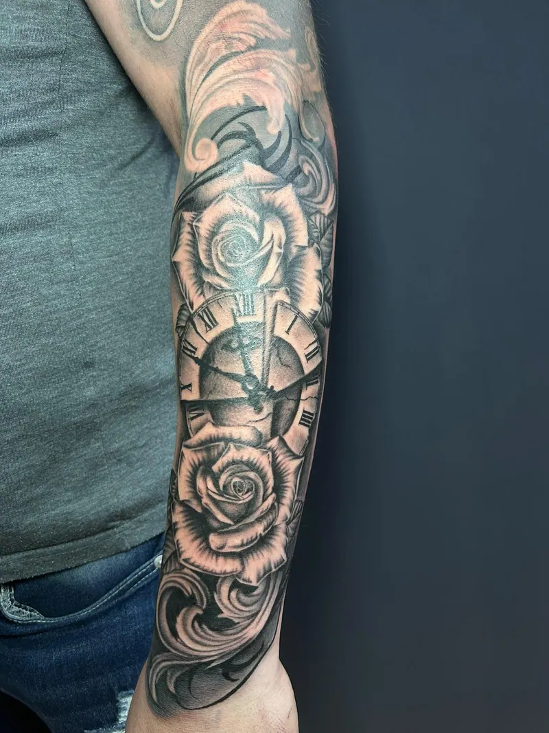 Black-&-Grey-Tattoo mit Rosen, Taschenuhr und Ornamenten am Unterarm, gestochen von Cindy