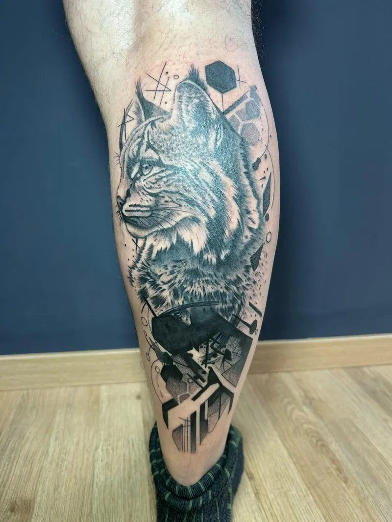Black-&-Grey-Tattoo eines Luchskopfs mit geometrischen Formen an der Wade, gestochen von Cindy
