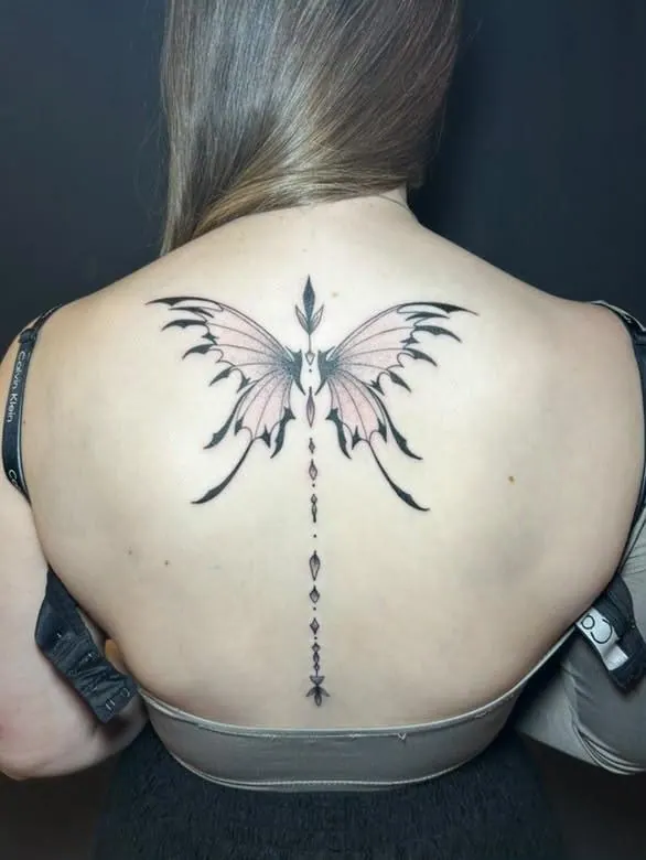 Fineline-Rückentattoo eines Schmetterlings mit ornamentaler Linie entlang der Wirbelsäule, gestochen von Cindy