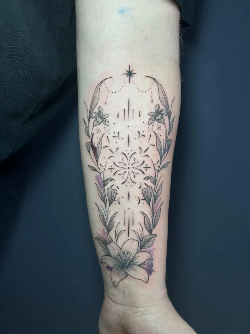 Fineline-Tattoo mit Lilien, Ornamenten und Halbmonden am Unterarm, gestochen von Cindy