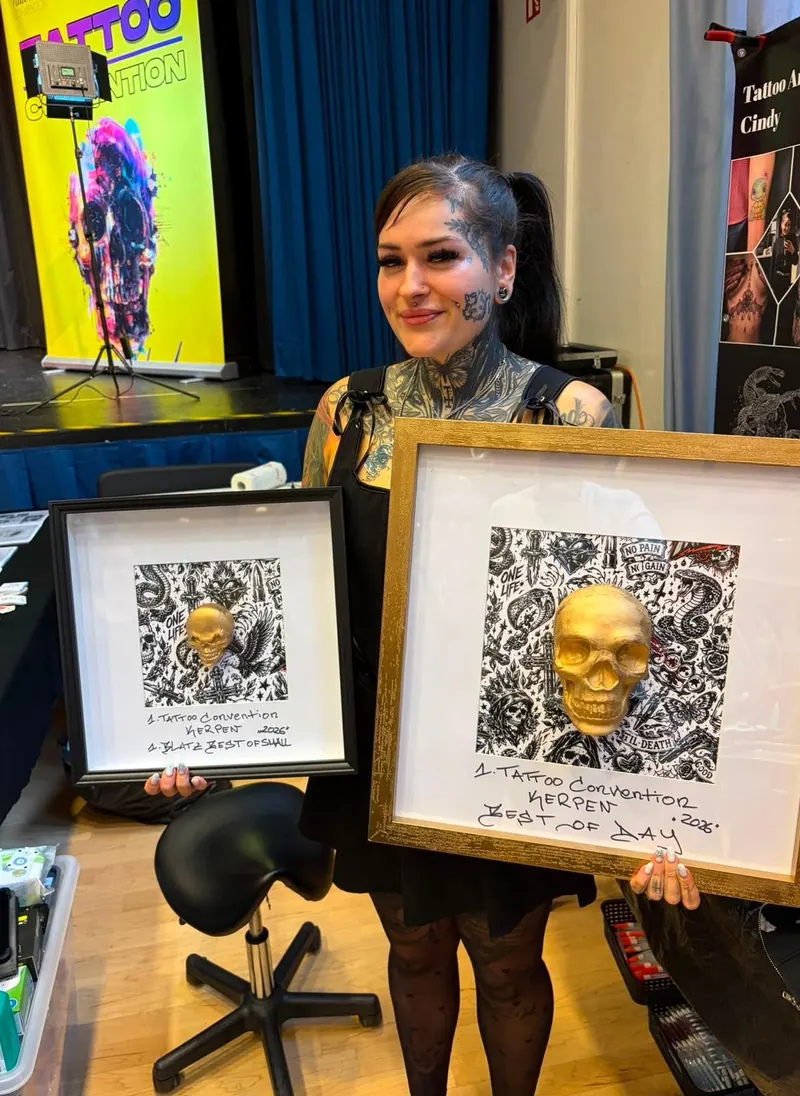Cindy mit zwei gerahmten Auszeichnungen der Tattoo Convention Kerpen