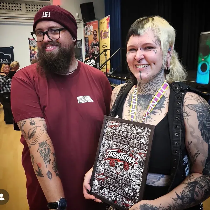 Motte mit gerahmter Siegerurkunde der Tattoo Convention Kerpen, daneben ihr Kunde