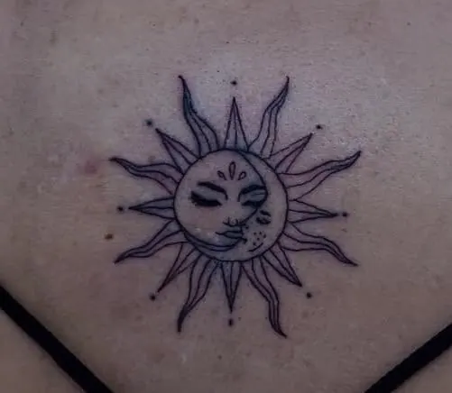 Fineline-Tattoo einer Sonne mit Mondgesicht am Oberkörper, gestochen von Paul