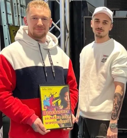 Paul mit der Siegerurkunde Black & Grey der Tattoo Convention Wipperfürth, daneben sein Kunde