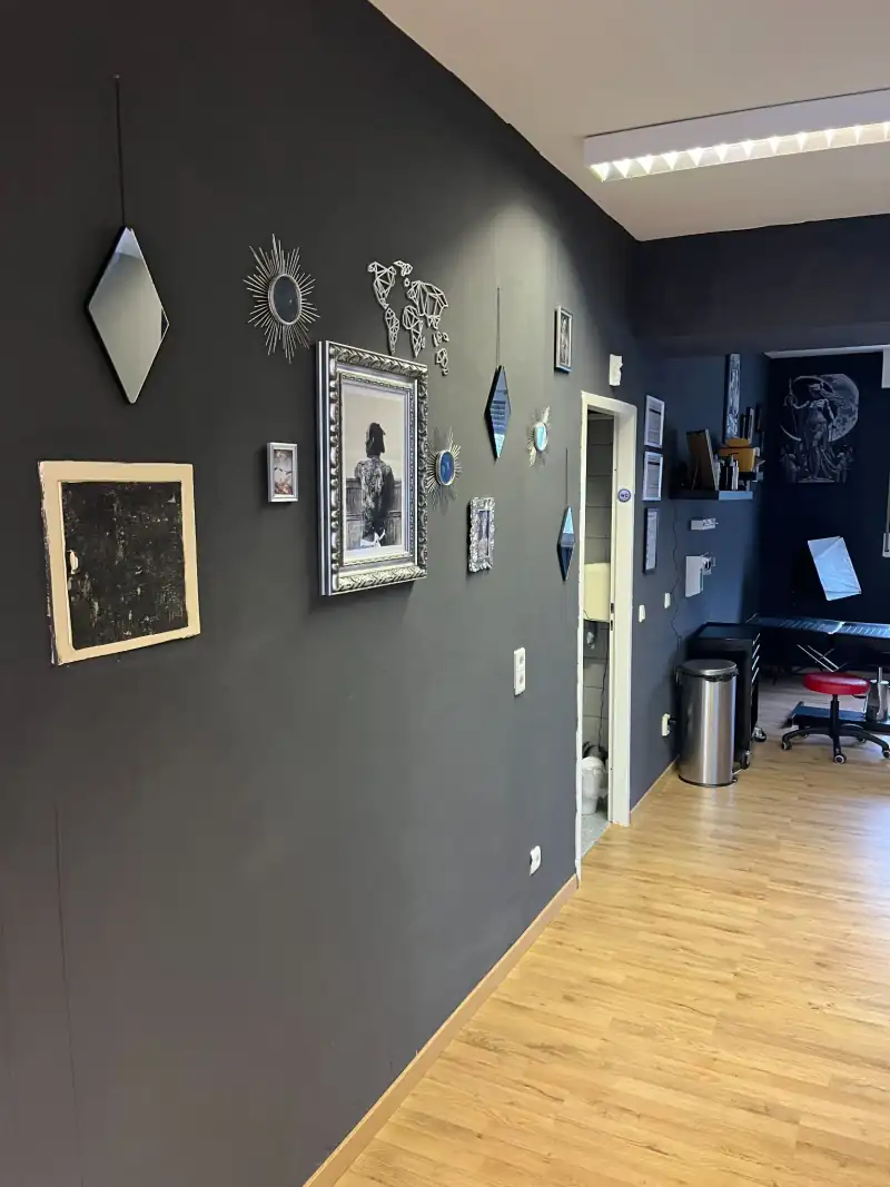 Flur im Studio mit dunkler Wand, Bildern und Spiegeln